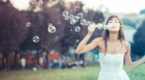 Woman in wedding dress blowing bubbles