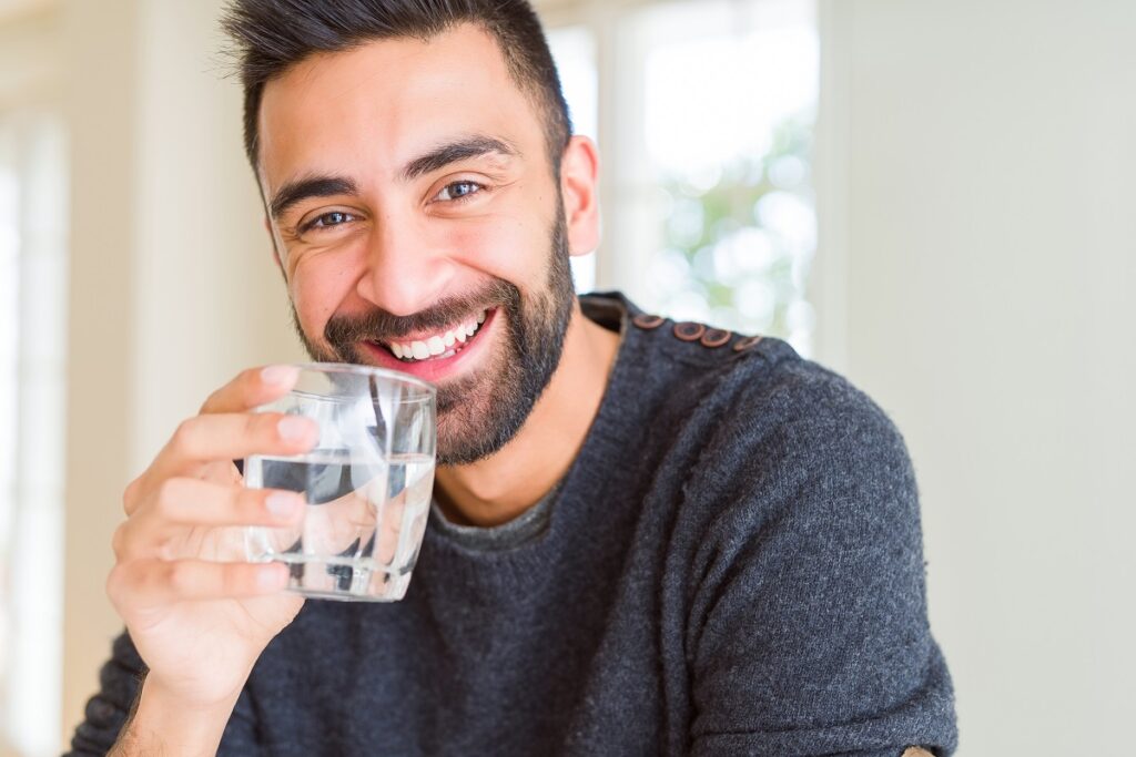 Handsome man drinking a fresh glass of water