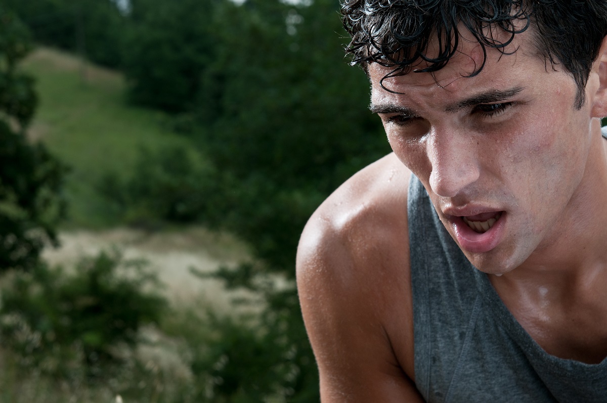 Young athletic man taking a break during jogging