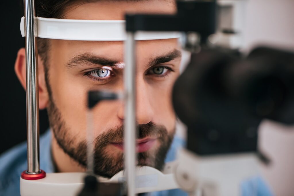 Handsome young man is checking the eye vision in modern ophthalmology clinic