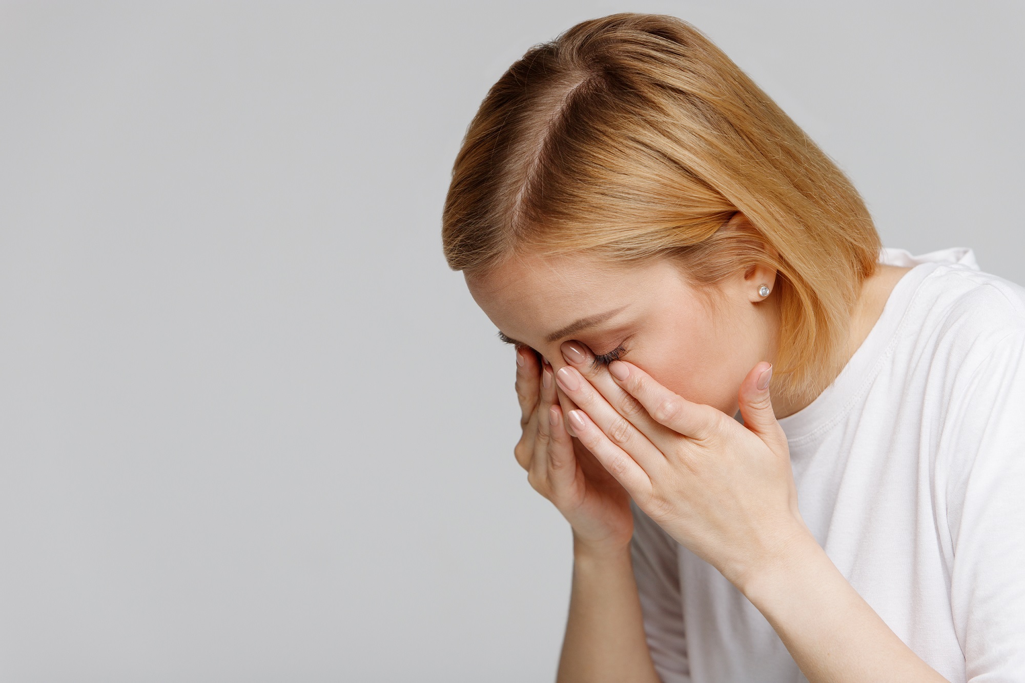 Young woman rubbing her swollen eyes due to pollen